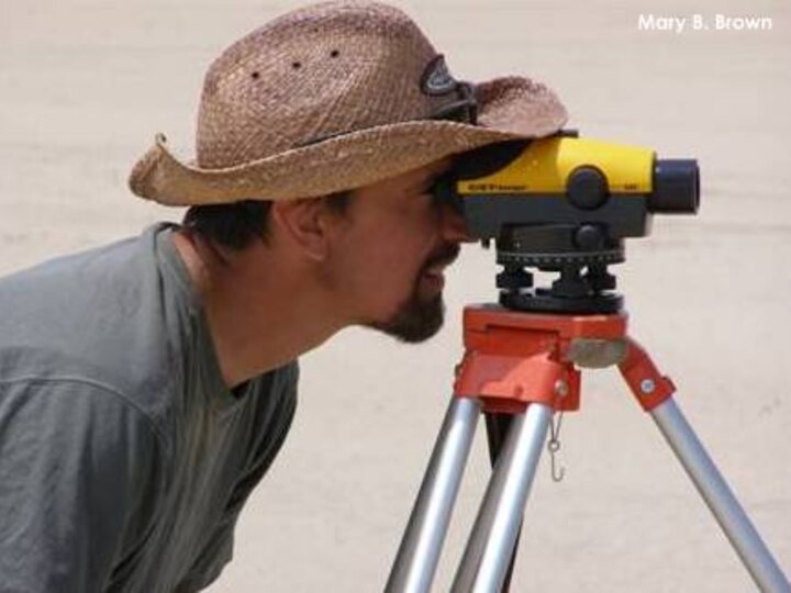 Joel Jorgensen surveying the topography of a sandbar